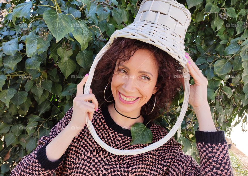 Funny Portrait of Young Woman Posing With Basket on Head, Smiling with Happy Face