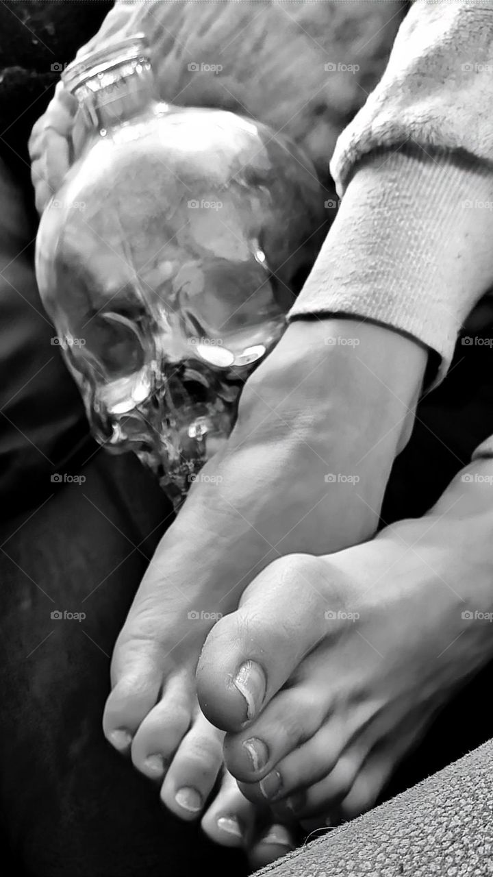 Bare Feet next to a glass skull