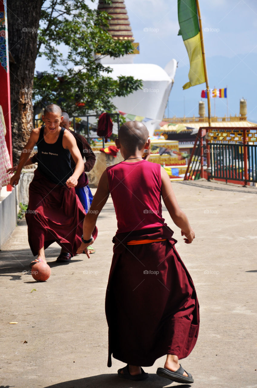 buddhist monks playing football in the monastery backyard near Kathmandu