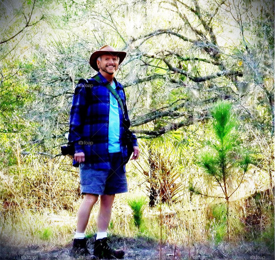 Dad hiking in a sunlit forest.