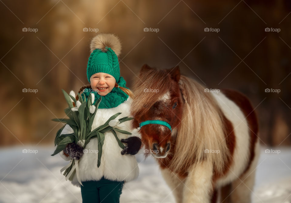 Little girl with pony at early spring day