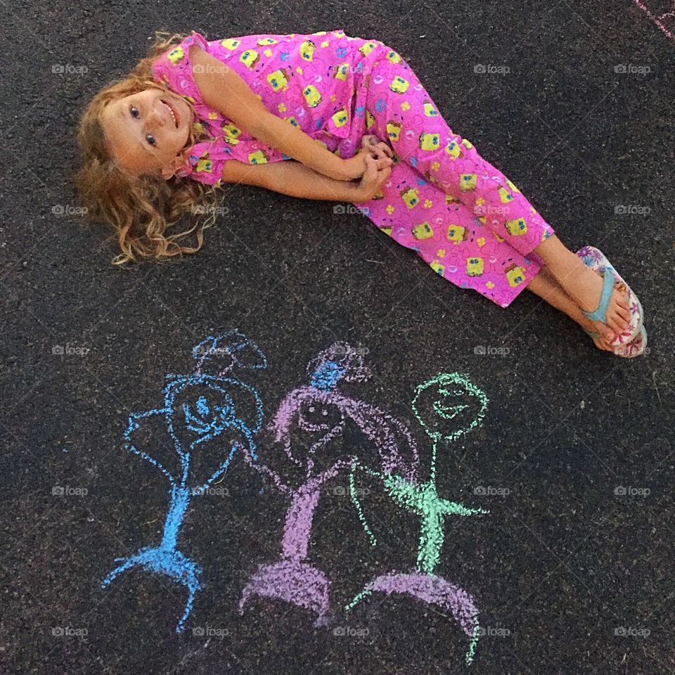 Girl lying on road with drawing