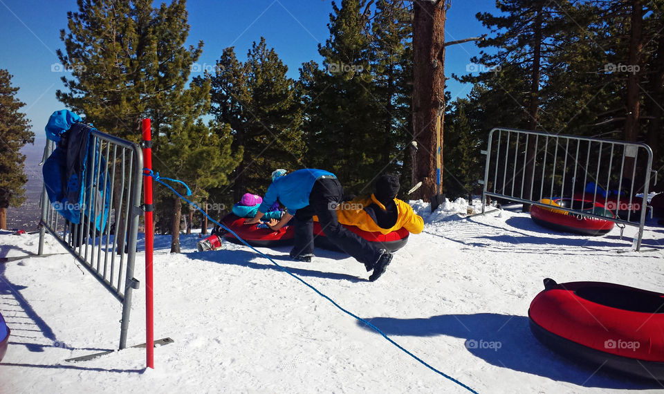 snow tubing park during winter, getting ready for the ride, dad and daughter