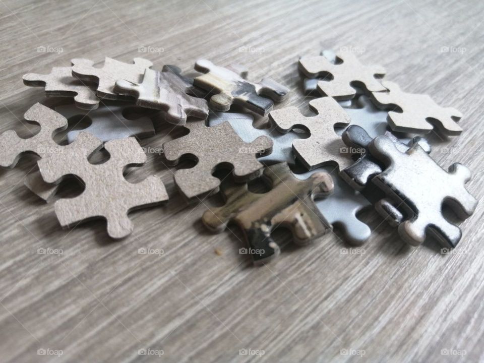 Puzzles are scattered on the floor of gray boards