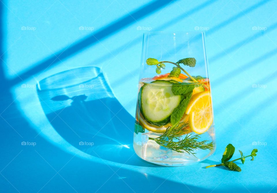 A glass of water with orange, lemon, ginger, cucumber and mint