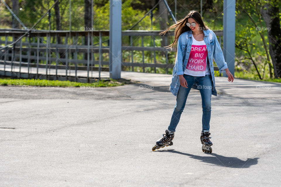 A young woman in sunglasses on roller skates.