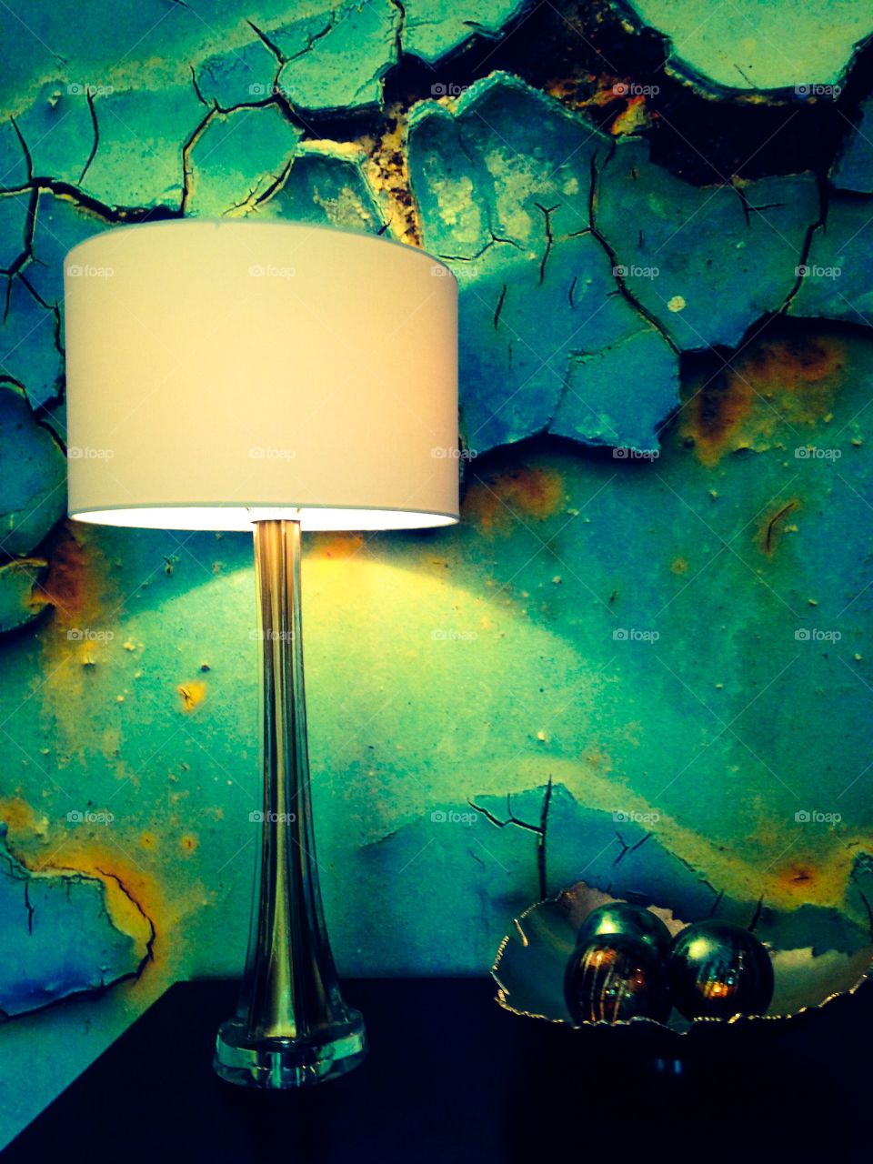 Cracked and peeling paint mural with vintage lamp and table decor 