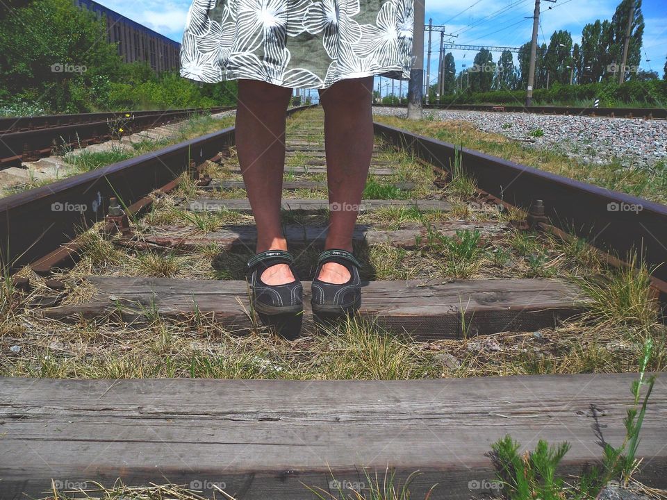 female feet on railway tracks