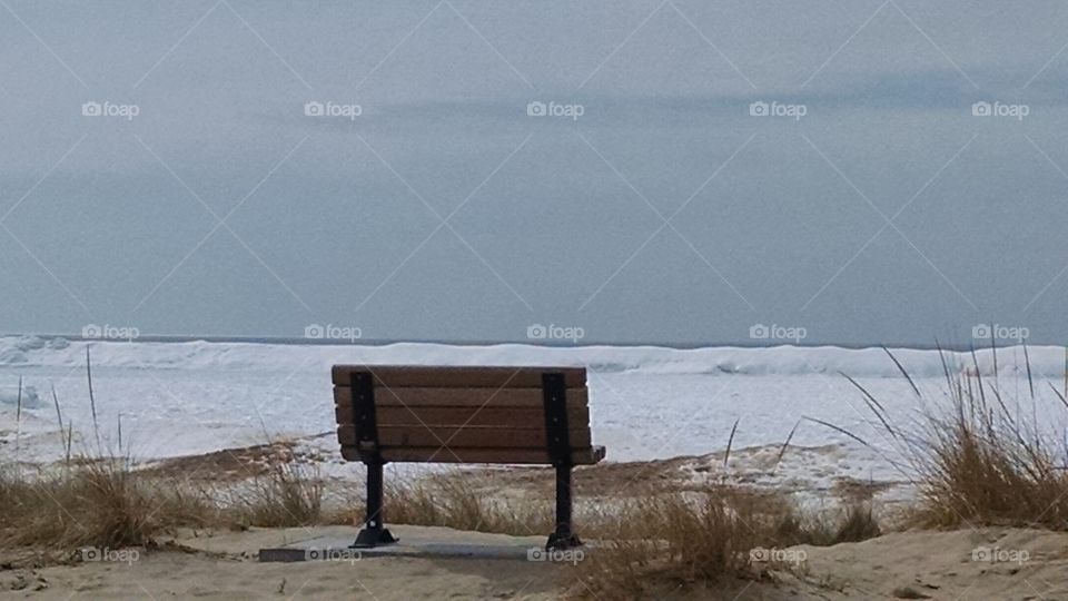 Bench at the frozen shore line. Beautiful town of Frankfort Michigan
