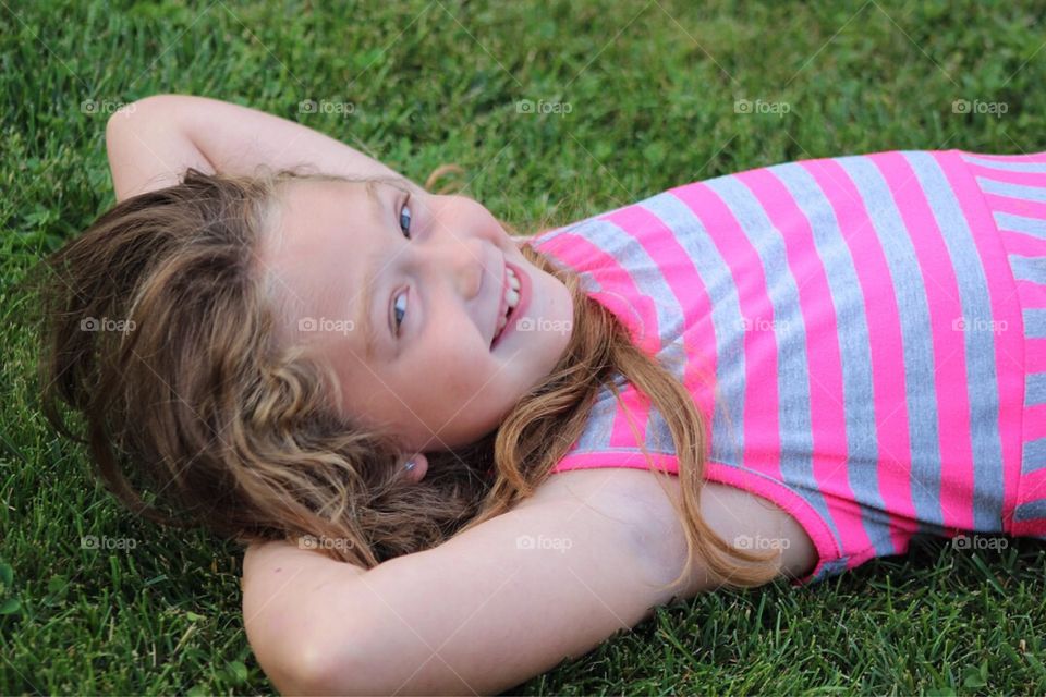 Smiling girl lying in grass