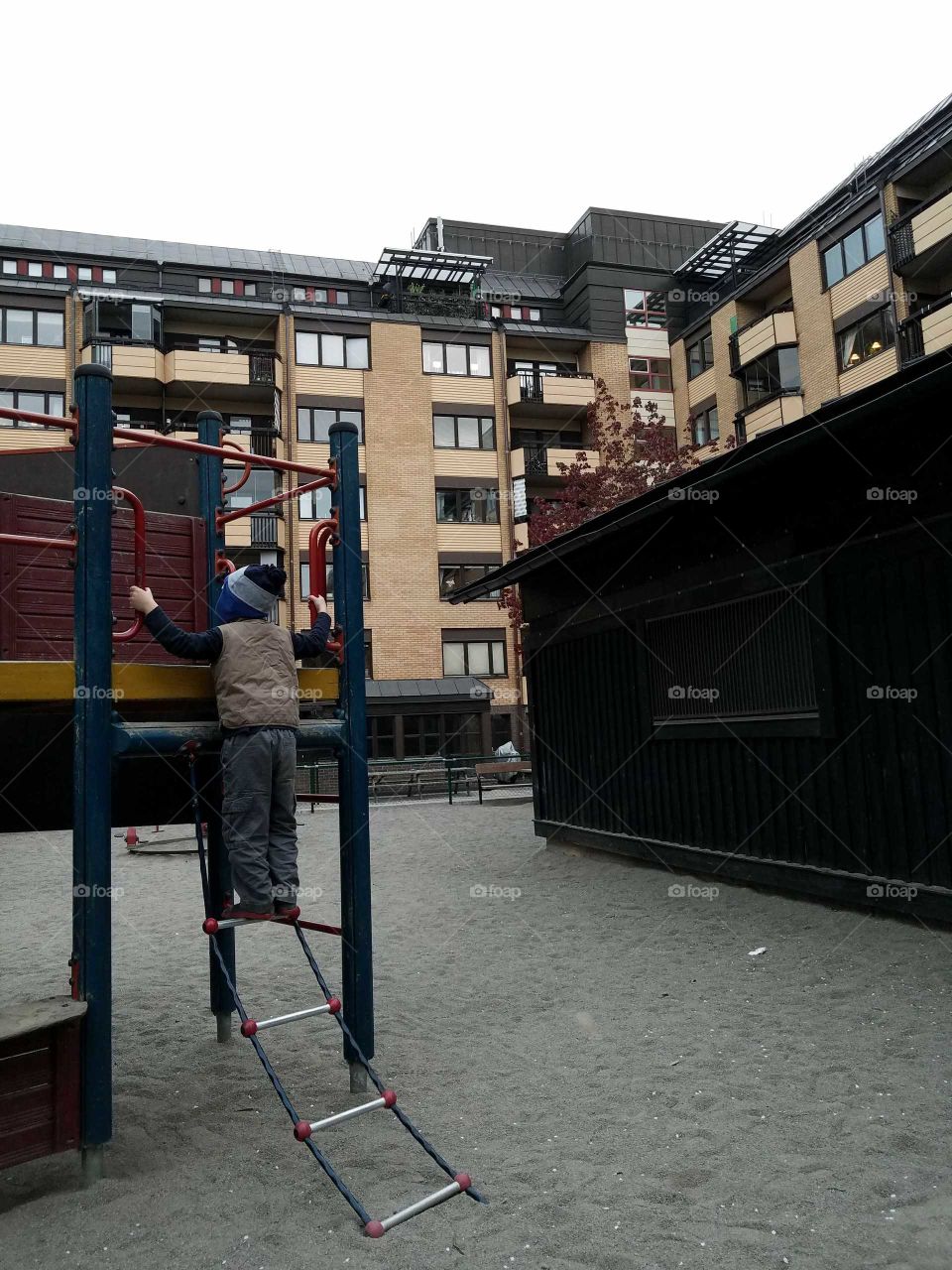 boy climbing up playground ladder