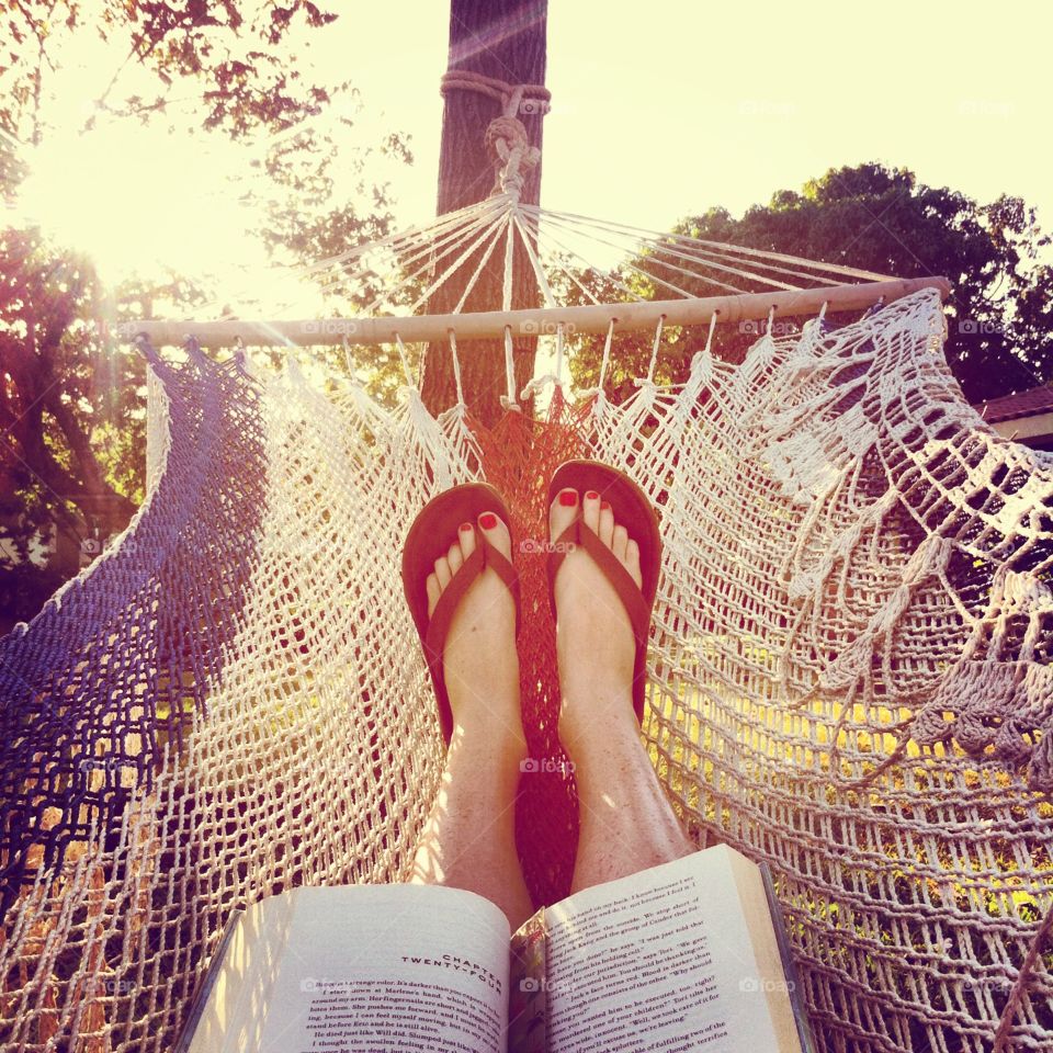 Summer relaxation in a hammock with a book