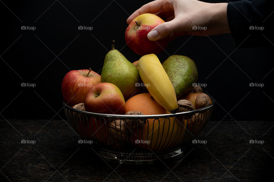 fruits and a person taking an apple