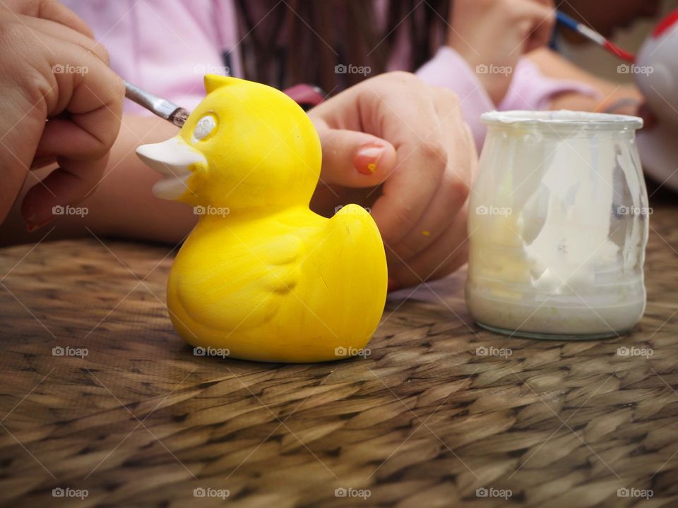 A girl painting a Yellow duck
