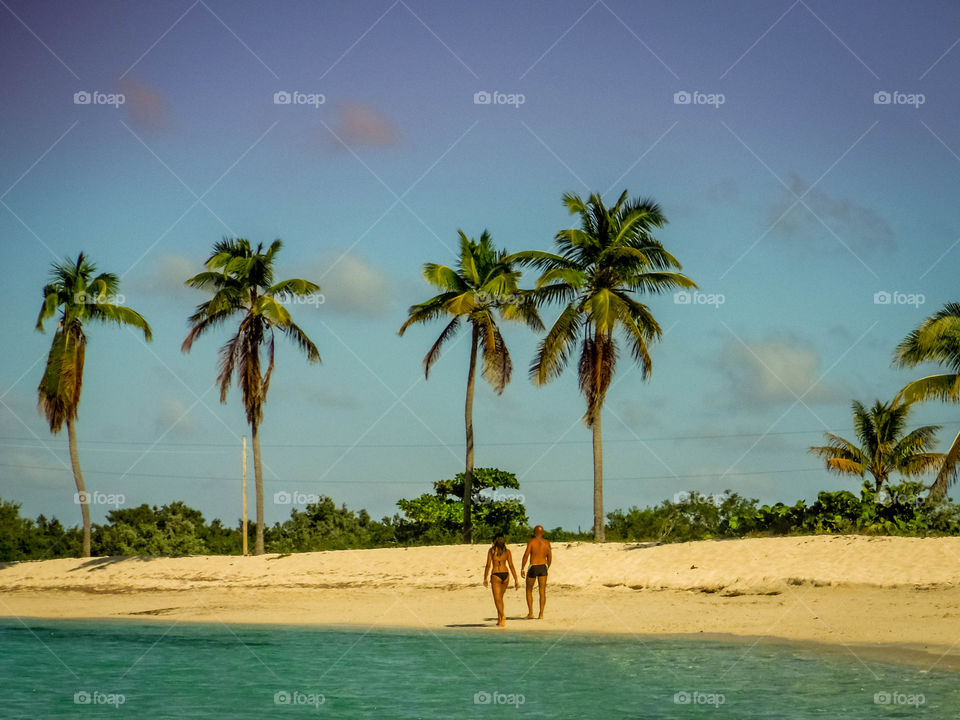 Couple is walking on a beach by the ocean