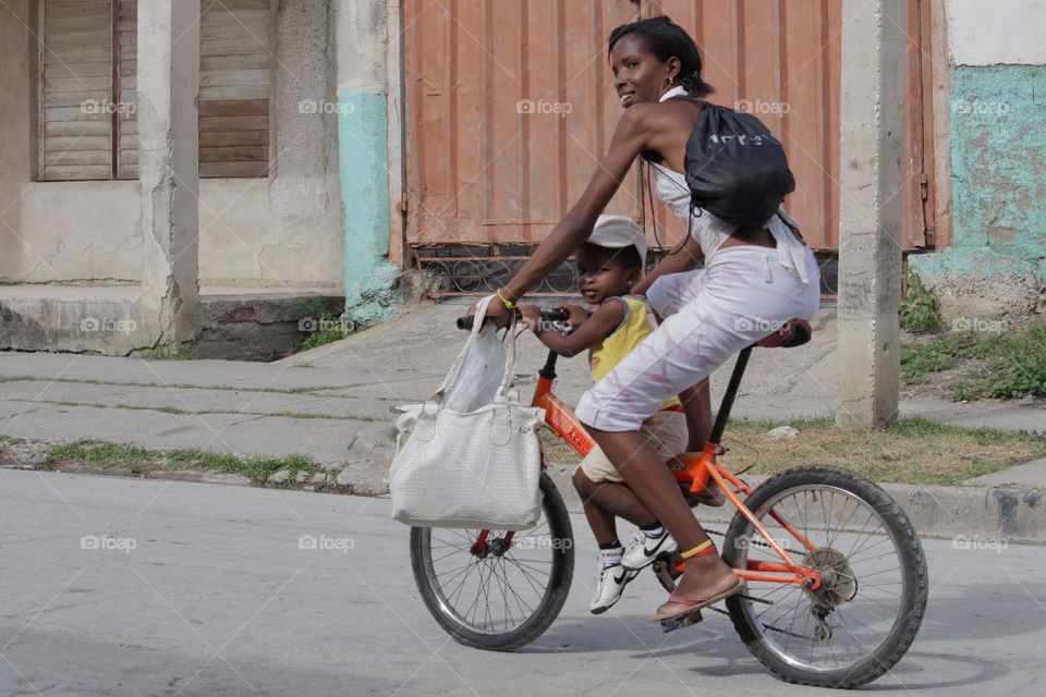 Cuban People.Mother and son riding a bike.
