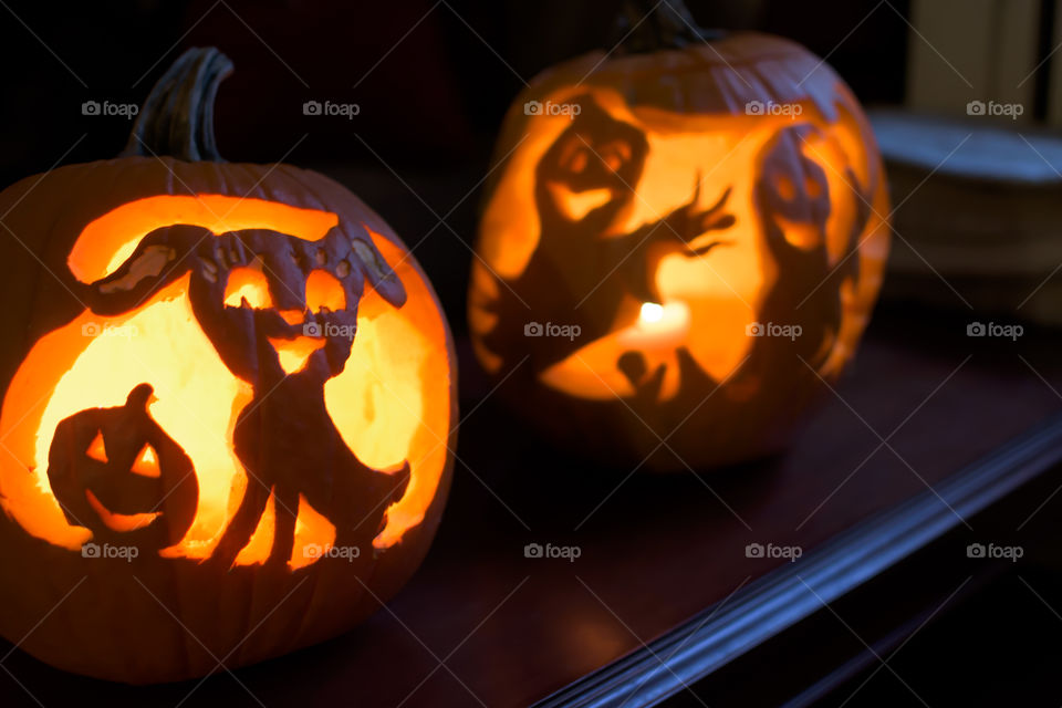 Cute and friendly Halloween pumpkins indoors on wood table Halloween illuminated jack o’lantern 