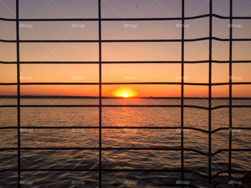 Sunset through wire fence