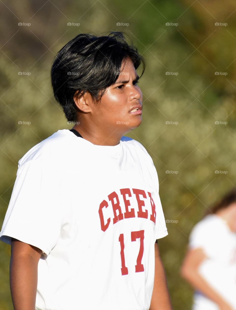 Girl with short black hair playing soccer