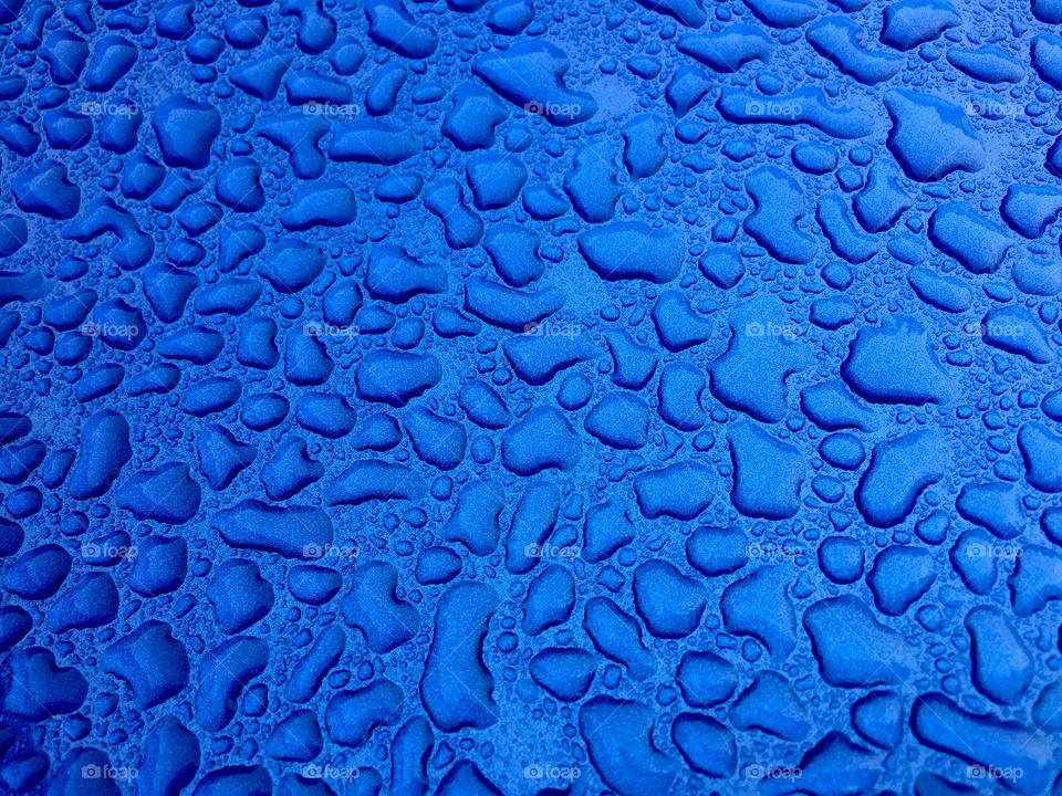 Water droplets on a metallic blue background