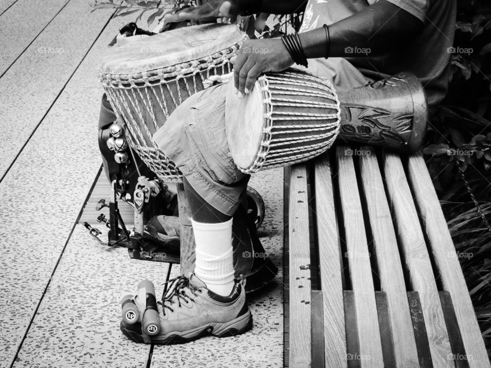 Music Man. A street musician in New York, performing as a one-man band for passers by, playing on drums, done in black & white