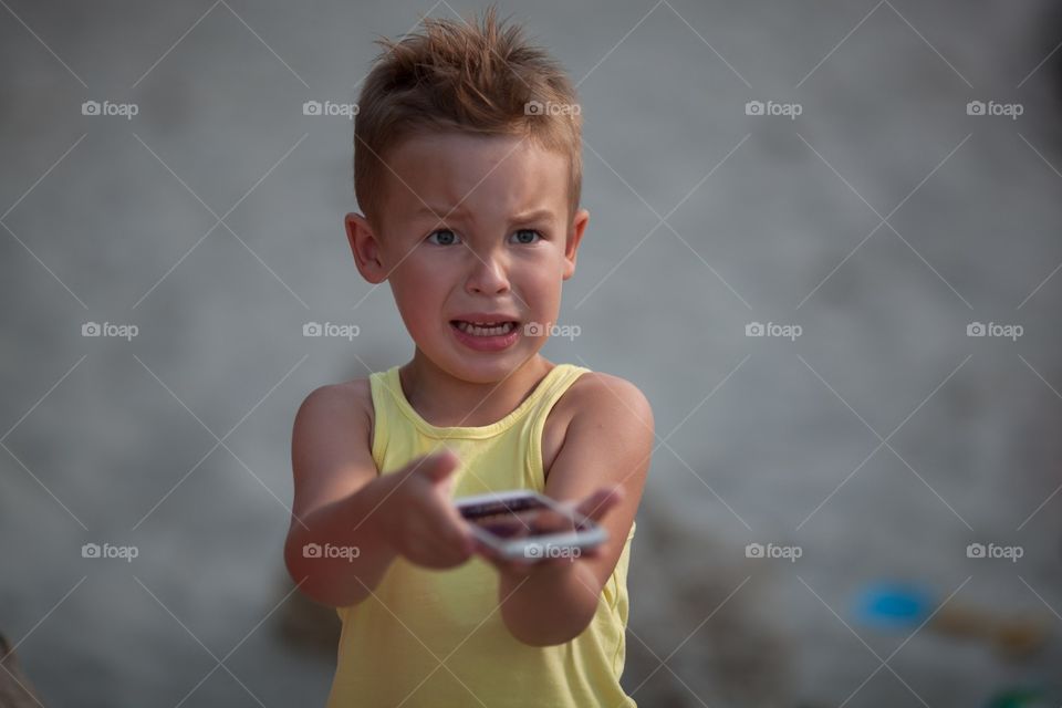 child's emotions. a boy with a vivid emotion. Child angry phone