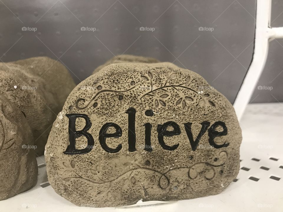 A nice rock with swirly scrolls that says believe. USA, America 