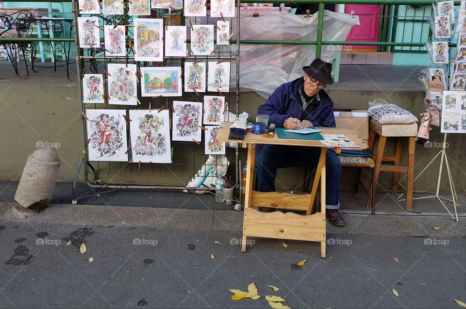 old man painting in The street