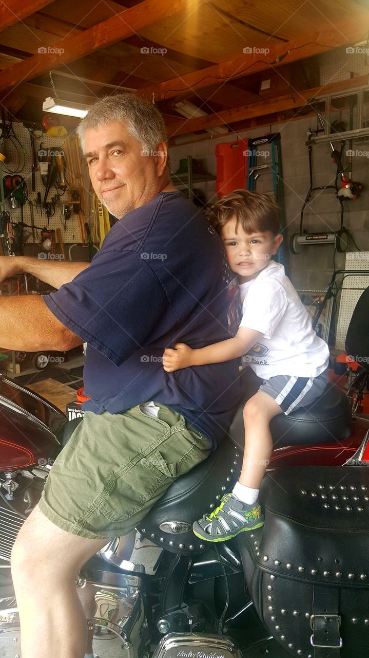 Father sitting with son on motorcycle