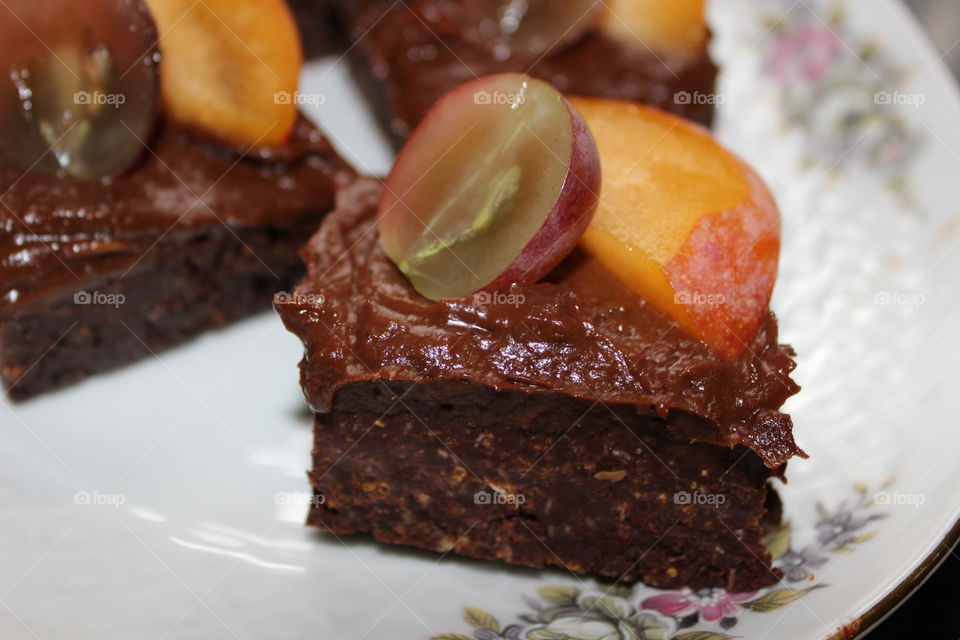 Raw chocolate cake made of walnuts, dates, agave syrup and coconut butter.
topped with raw avocado frosting and some fresh organic fruits