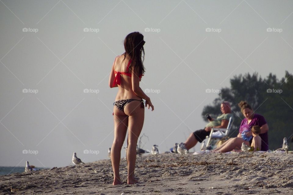 Woman enjoying the summer heat in an itsy bitsy tback bikini.