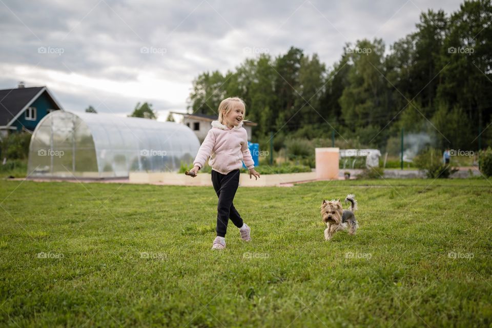 Kid playing with dog on backyard 