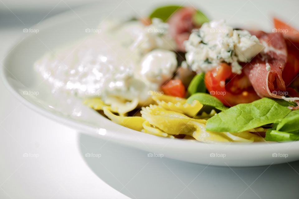 close-up of a young man eating a salad in a light kitchen