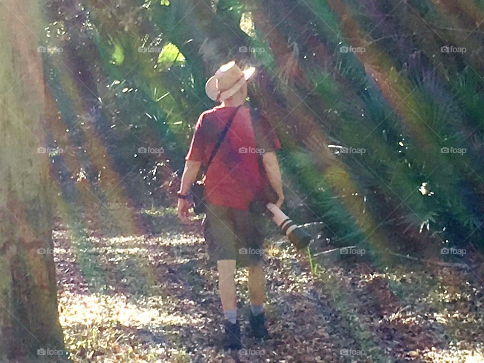 Rainbow light rays on a happy summer hiker on a warm spring day.
