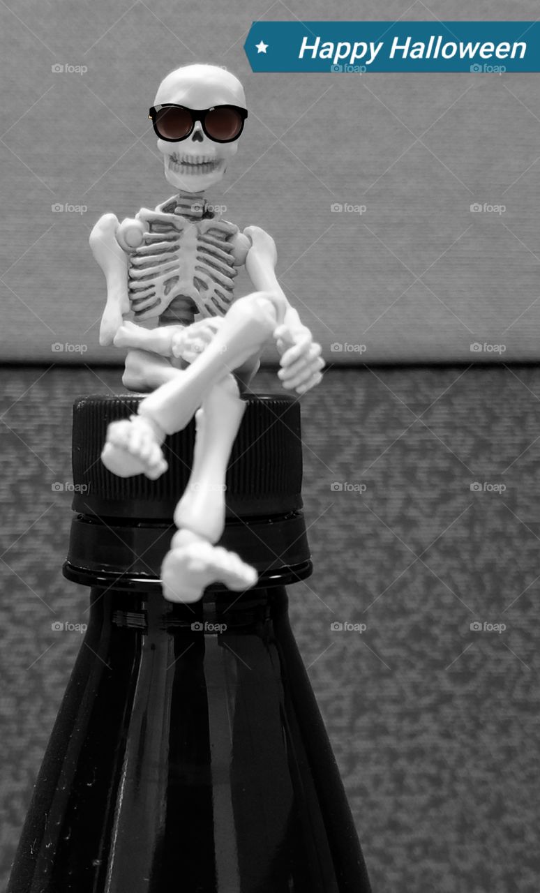 Skeleton sitting on bottle