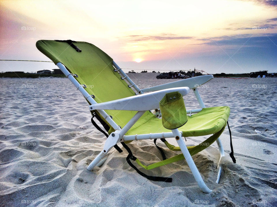 Empty deck chair on sand at beach