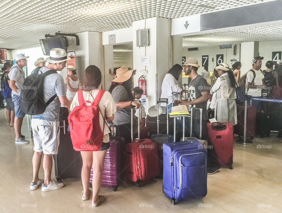 Passengers Queue Waiting For Check In At The Airport