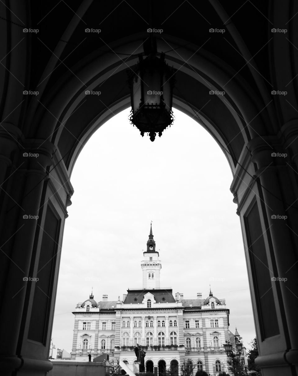 city hall in novi sad. city hall of novi sad in serbia with a view from a cathedral arch