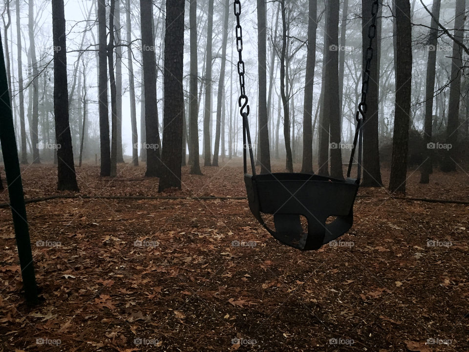 Desolate lonely playground in a woody area on a foggy morning at a park in North Carolina 