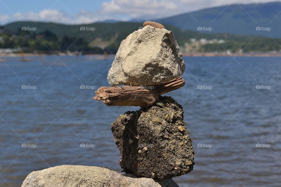 Stack of Balanced Sticks and stones by Ocean. Stack of Balanced Stones rocks and sticks by Ocean, Cairn, Inuksuk