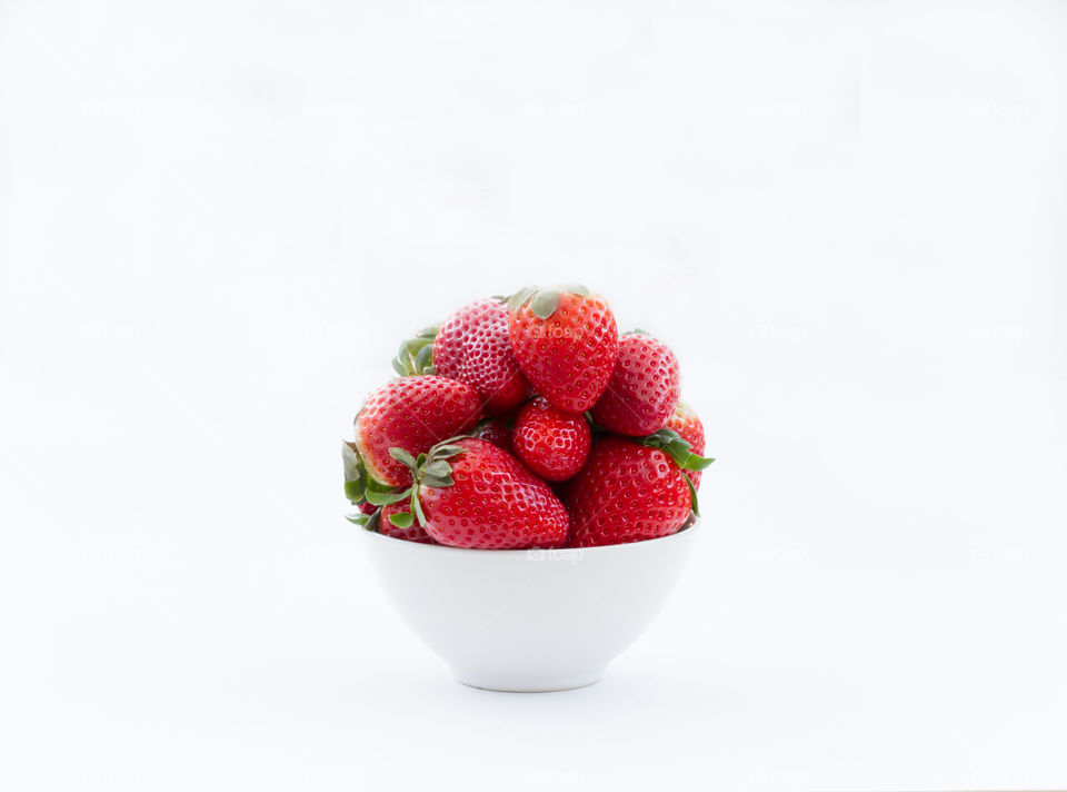 A bowl of fresh, organic  strawberries on a white background.