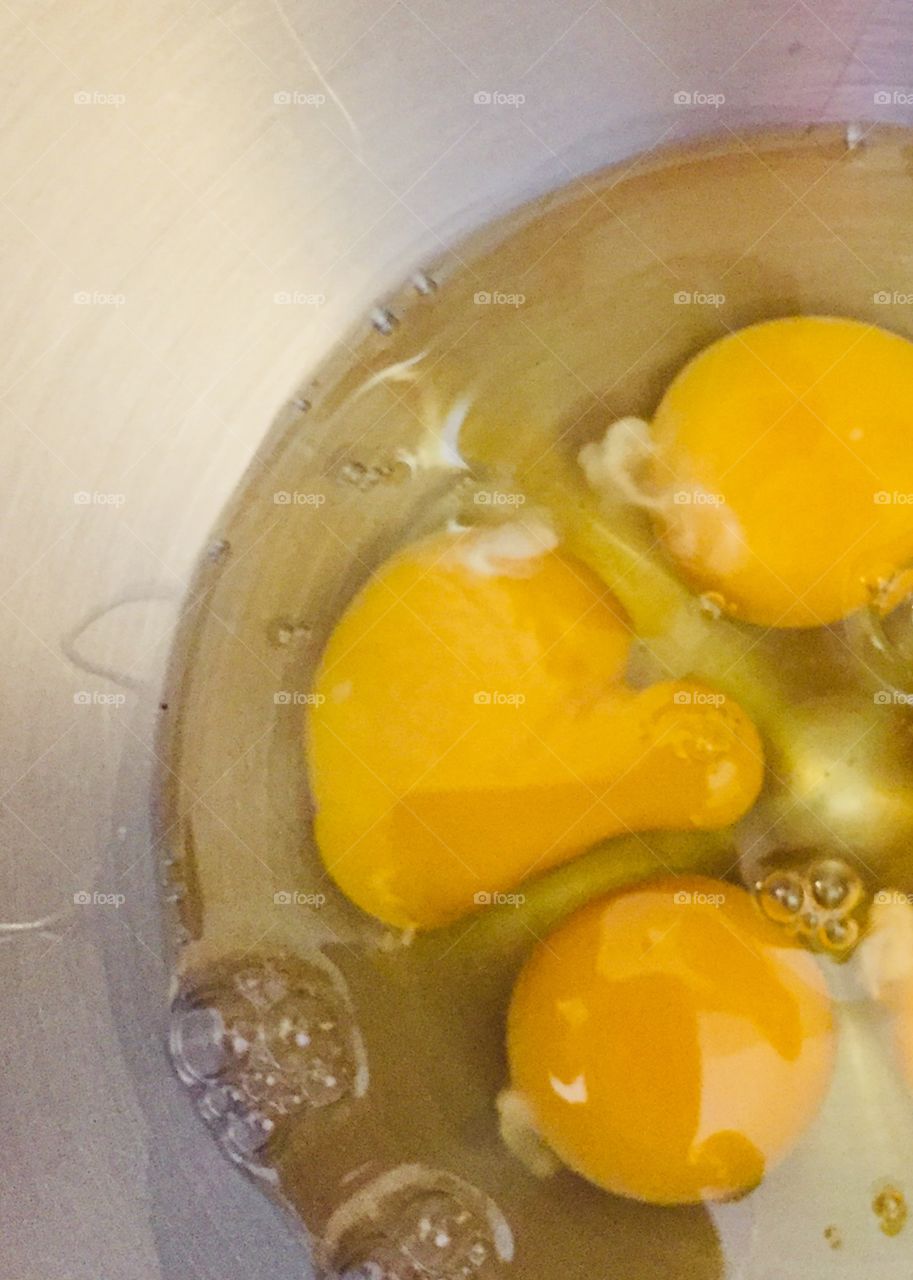 Opened eggs in a metal bowl