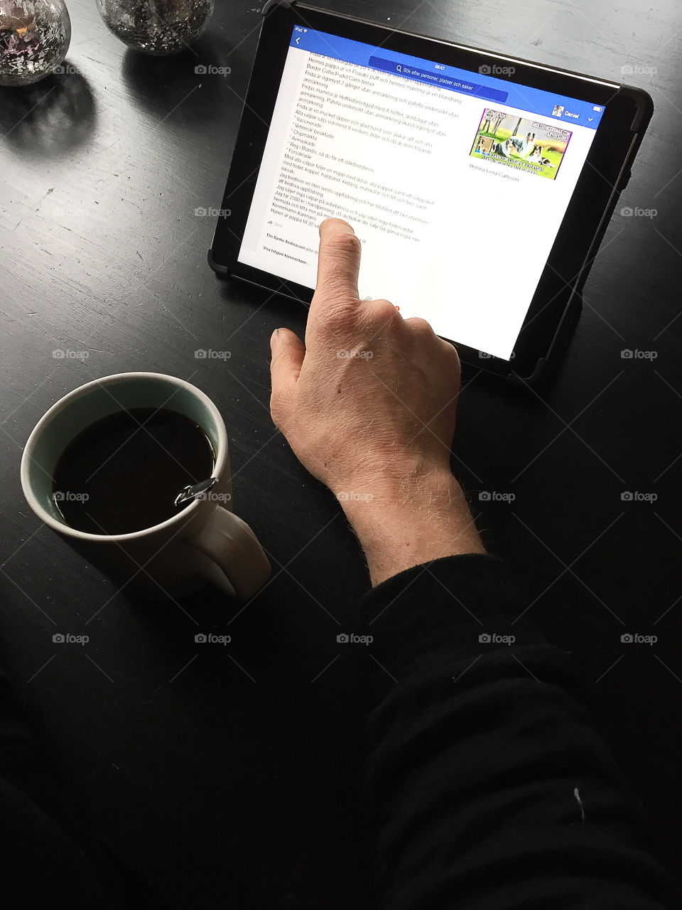 Man using a tablet while drinking coffee