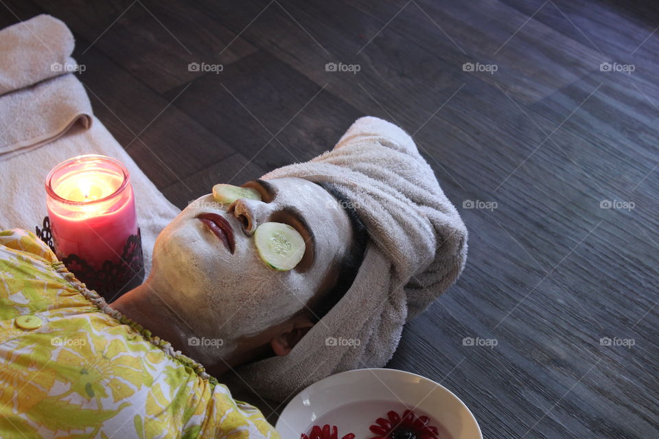 Woman with face mask and cucumber slice on eyes