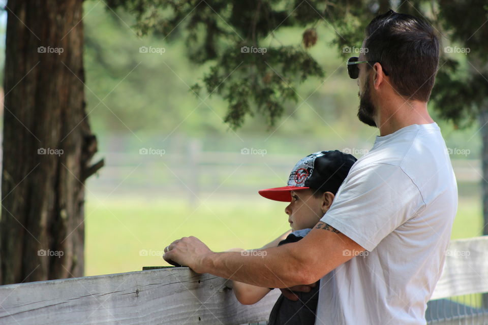 Man and son standing near fence