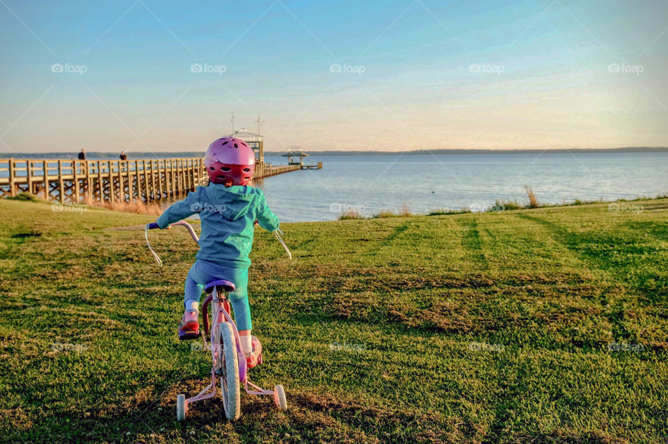 Foap, Cities and Countrysides: A little girl rides her bike to the pier at the Neuse River estuary at Camp Seafarer in North Carolina 