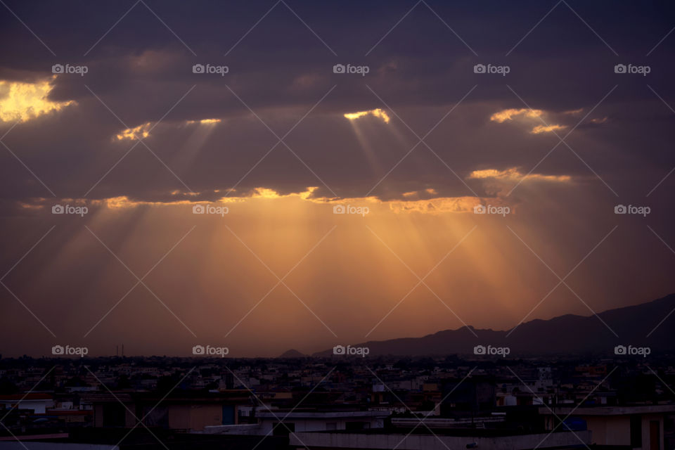 Duel Between Sun & Clouds. The last rays of syn piercing through the clouds after a brief rain spell in Islamabad, Pakistan.