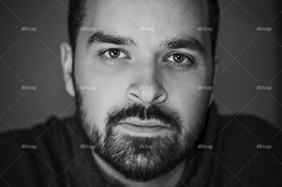 A MALE MODEL POSES FOR THE CAMERA WITH A CONTEMPLATIVE LOOK.