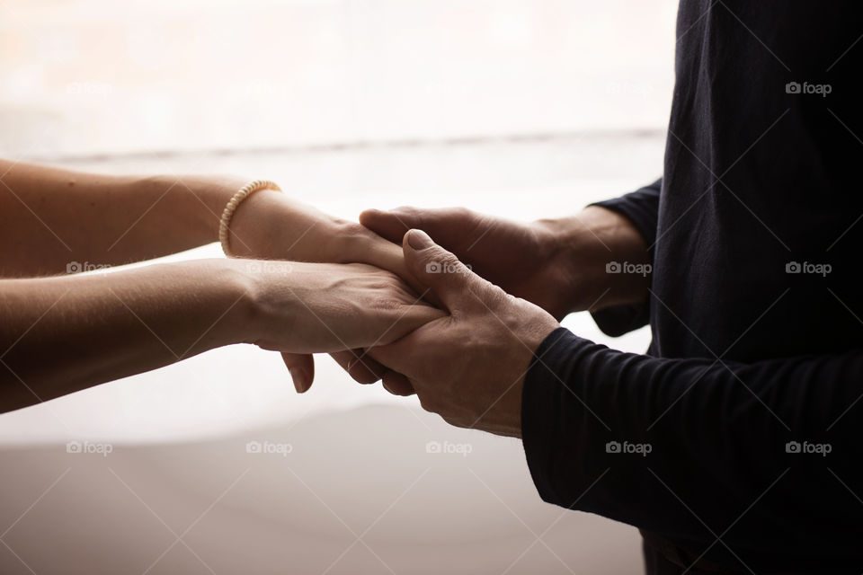 man holding woman's hands
