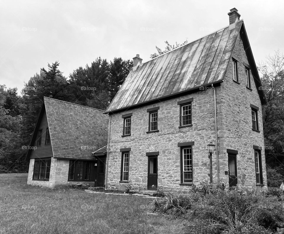 Black and white photo of the restored, rural, stone Brisbane House, built in 1868, and located in Arena, Wisconsin, USA